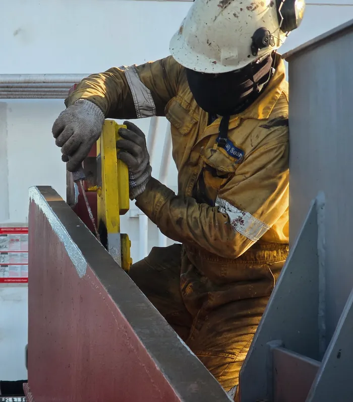 Worker operating offshore rig machinery