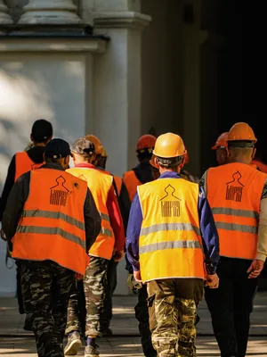 Site team in orange vests walking through a plant
