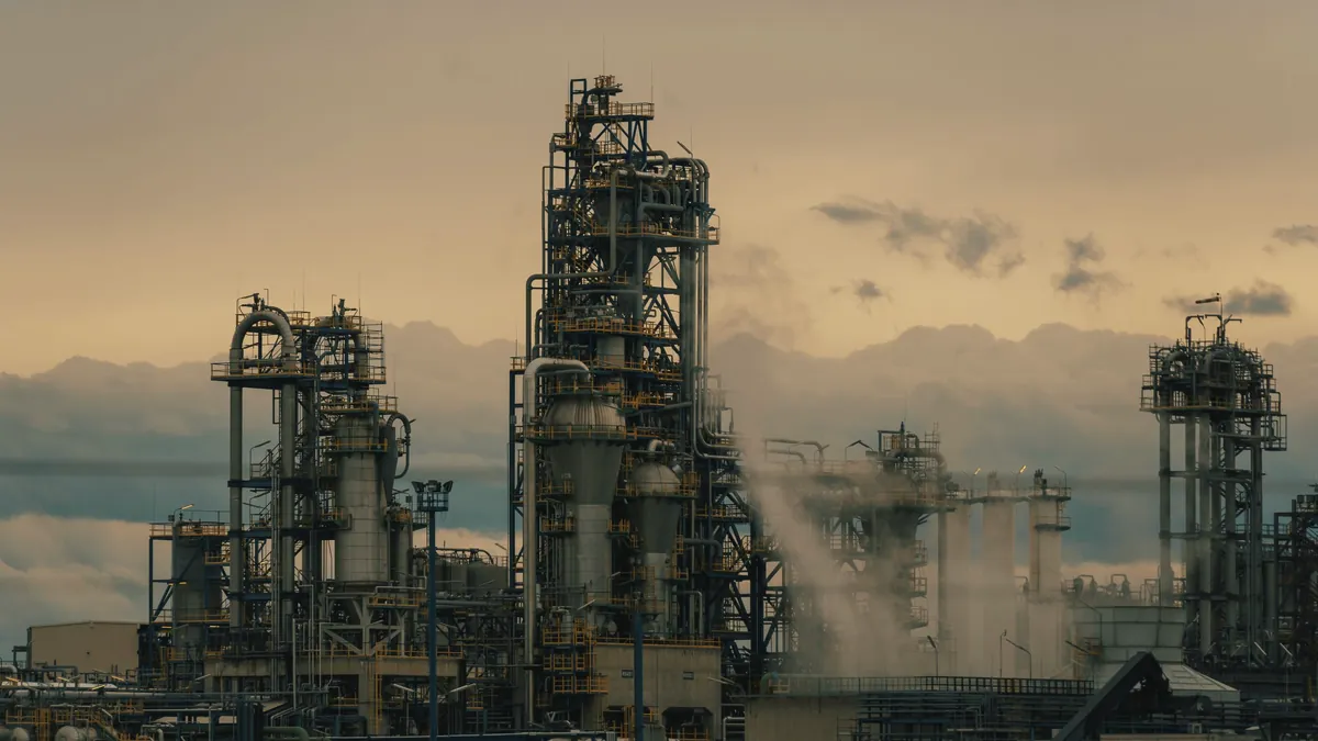 Refinery towers under a dusk sky