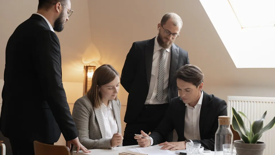 Four professionals working through documents